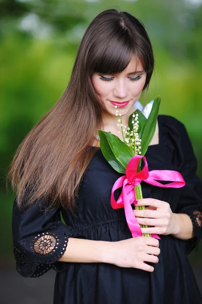 Girl with lilies of the valley in the spring — Stock Photo, Image