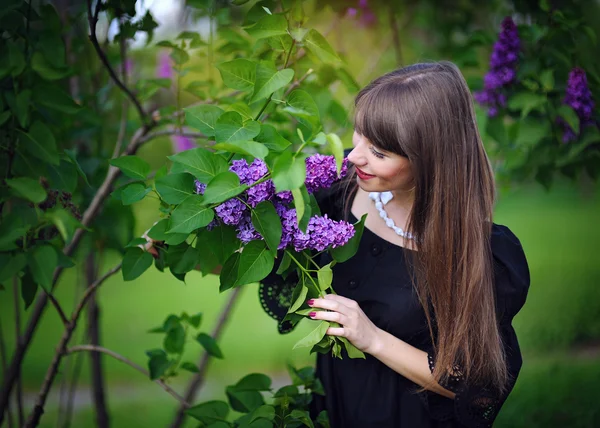 Menina com lilases na primavera no parque — Fotografia de Stock