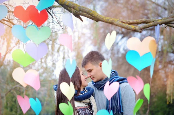 Hombre y mujer amorosos en el parque con la decoración de los corazones — Foto de Stock