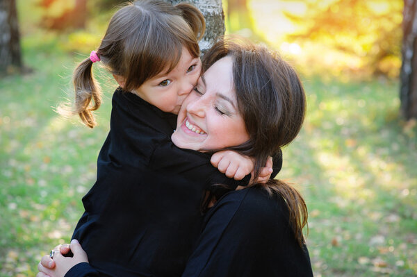 daughter kissing her mother in the park