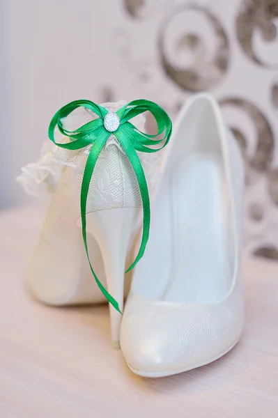 Elegant bridal shoes and a white garter — Stock Photo, Image