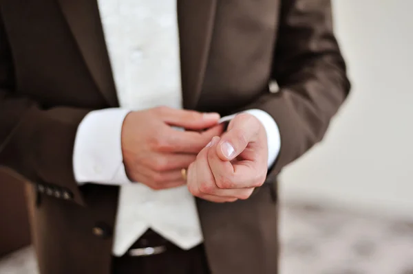 Handen van een man in een bruin pak — Stockfoto