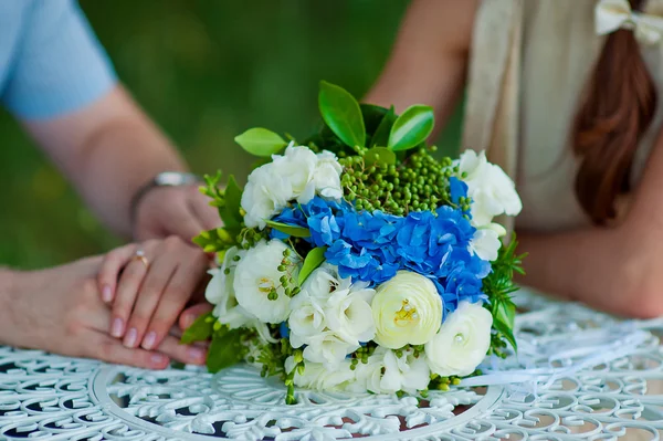 Bridal bouquet and hands of the bride and groom — Stock Photo, Image