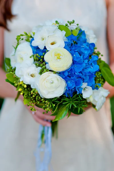 Невеста держит свадебный букет из голубых гортензий цветов — стоковое фото