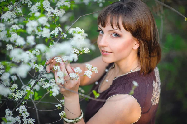 Vakker kvinne i hvite blomster om våren – stockfoto