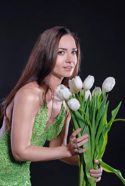 Красивая женщина с белыми тюльпанами весной в студии — стоковое фото