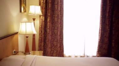 Bir lamba ve bir çift kişilik yatak ile otel odasında