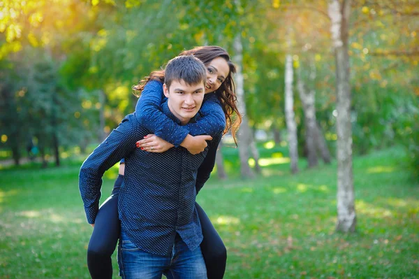 Young woman and a man walking in the park — Stock Photo, Image