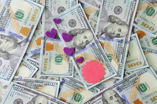 Hearts lie on money dollars, concept of love for money — Stock Photo, Image