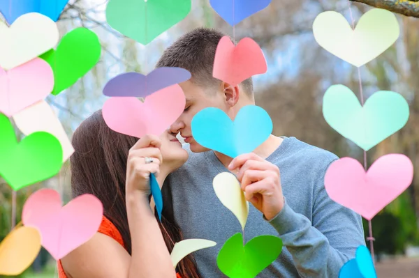 Casal apaixonado beijando na decoração dos corações, na festa — Fotografia de Stock