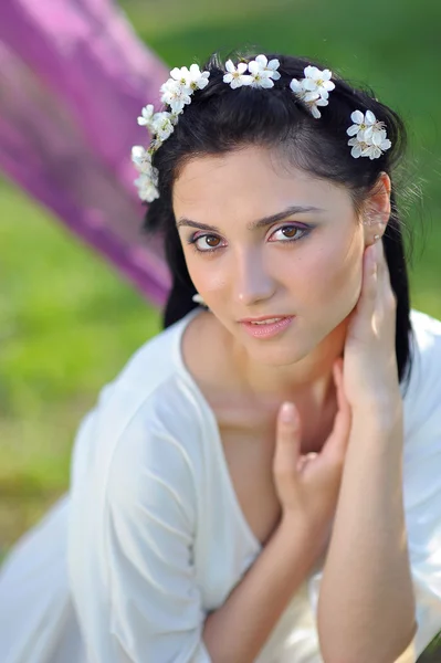 Jonge vrouw met Lentebloemen in het haar — Stockfoto