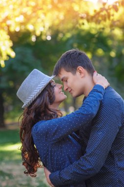 Genç aşık çift parkta yürüyor.