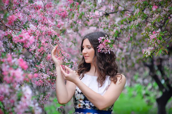 Portret van een mooie vrouw in een weelderige tuin in het voorjaar — Stockfoto