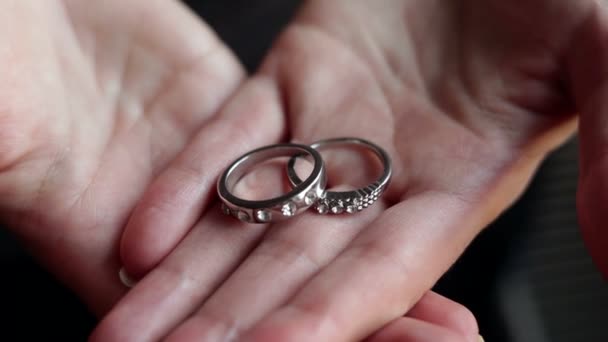 Hands of girl hold two rings — Stock Video