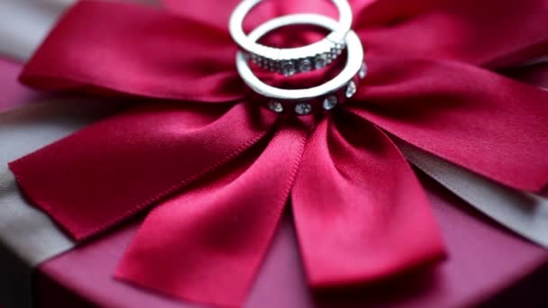 Anillos de boda en un lazo rojo — Vídeos de Stock