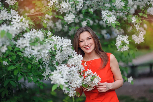 Beautiful happy brunette woman in the park on a warm summer day — Stock Photo, Image