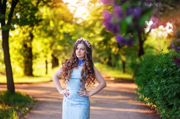 Beautiful young woman in the garden of lilacs in the spring — Stock Photo, Image