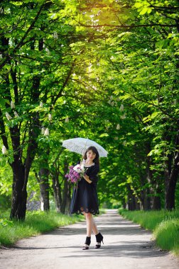 bir şemsiye ile bir bahar parkta genç kadın