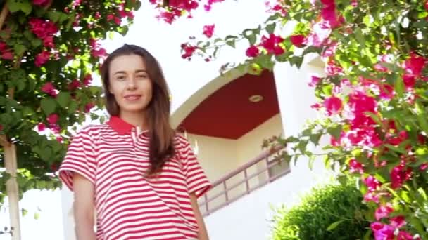 Jonge vrouw in de zomer met prachtige exotische bloemen — Stockvideo