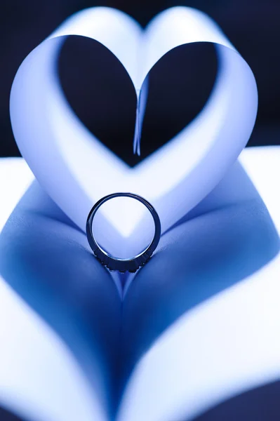 Обручальные кольца на фоне сердец — стоковое фото