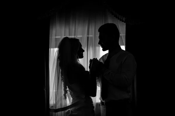 Silhueta de uma noiva e noivo na frente da janela — Fotografia de Stock