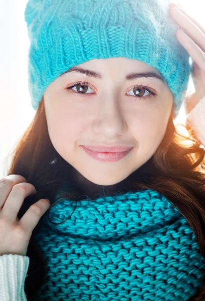 Молодая женщина в вязаном шарфе и шляпе солнечный свет позади — стоковое фото