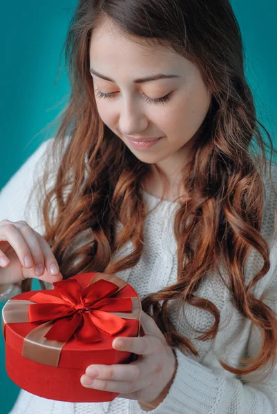 Young woman opens a gift — Stock Photo, Image