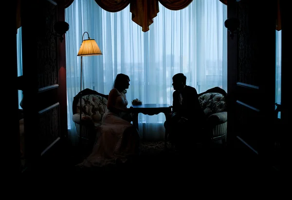 Sposa e sposo in silhouette seduti uno di fronte all'altro — Foto Stock