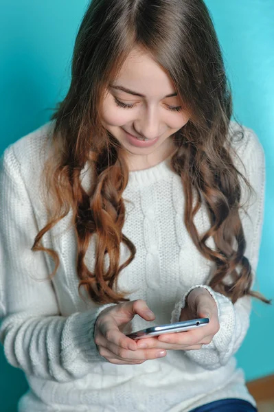 Menina adolescente jogando em seu telefone — Fotografia de Stock