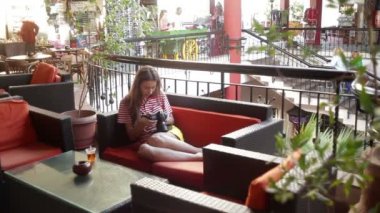 Kanepede oturan ve kameradan resimleri izlerken kız