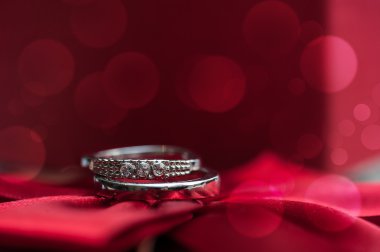 İki alyans bokeh bir kırmızı zemin üzerine