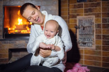 bir bebek kız tarafından şömine ile mutlu anne