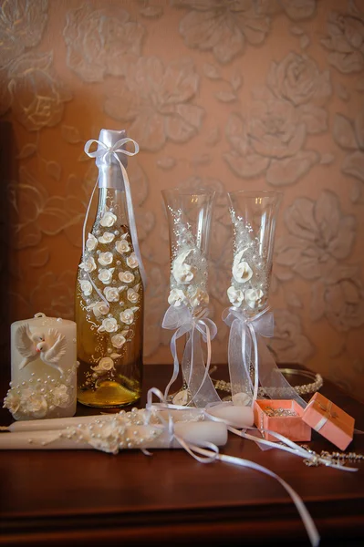 Hochzeitsgläser und eine Flasche weiße Rosen mit Dekor — Stockfoto