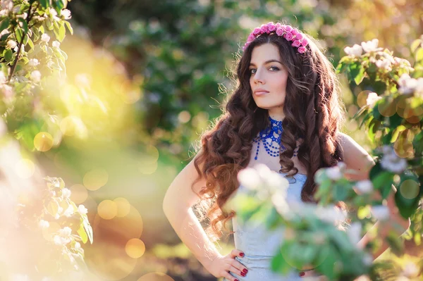 Bela jovem mulher em um parque de primavera com grinalda — Fotografia de Stock