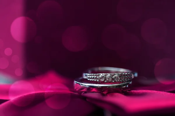 Anillos de boda sobre un fondo rosa — Foto de Stock