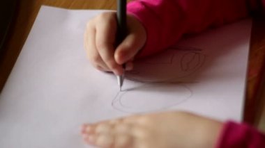 Küçük kız kalem kağıt üzerinde çizer.