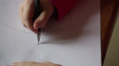 Küçük kız kalem kağıt üzerinde çizer.