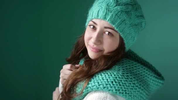 Chica sonriente en un sombrero de punto turquesa posando en la cámara — Vídeos de Stock