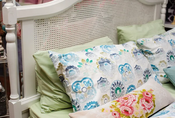 Цветные подушки лежат на кровати — стоковое фото