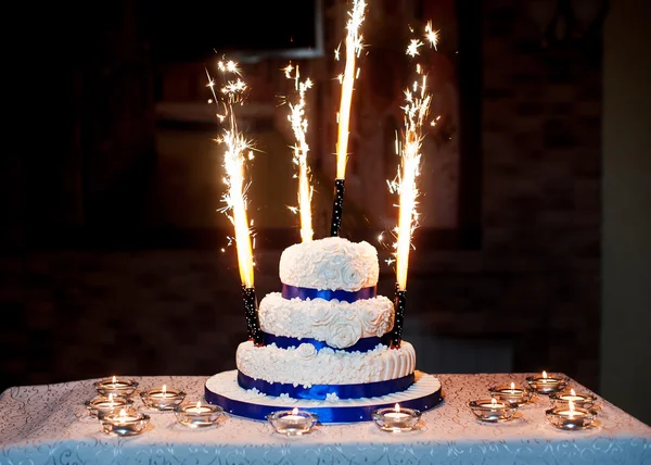 Beautiful three-layered wedding cake with fireworks — Stock Photo, Image