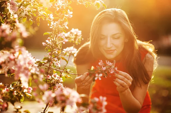 Vacker brunett i den blommande vår trädgården — Stockfoto