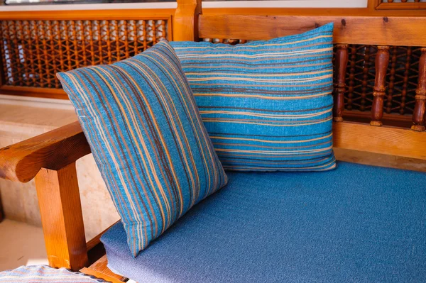 Two striped cushions lie on a wooden sofa — Stock Photo, Image