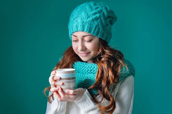 Hermosa chica en un sombrero de punto sosteniendo una taza de café — Foto de Stock