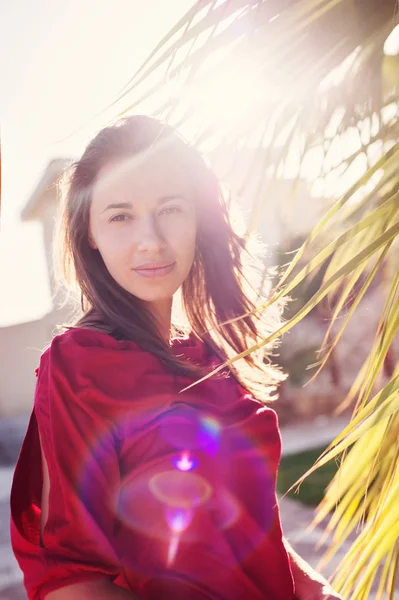 Schöne Mädchen in der Nähe der Palmen und Sonne hinterleuchtet — Stockfoto