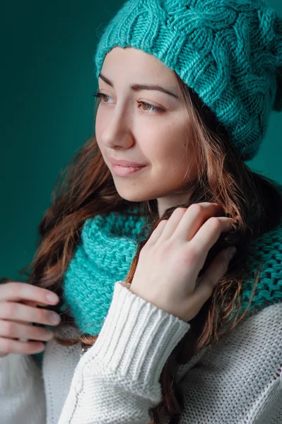 Mooi meisje in een gebreide muts kijkt uit het raam — Stockfoto