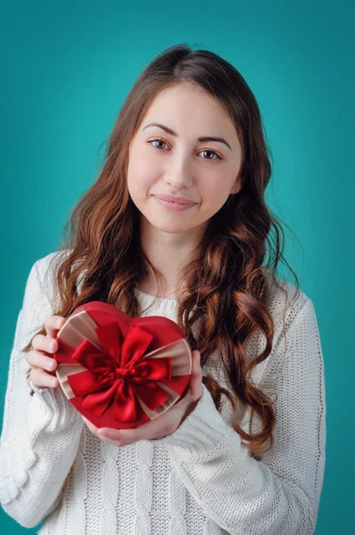 Beautiful girl holding a gift in the form of heart with a red bo — Stock Photo, Image