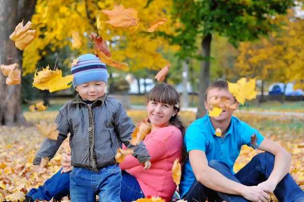 Young family with a child walks in autumn park — Stock Photo, Image