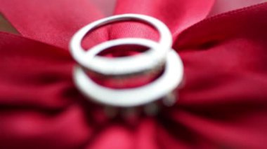 İki yüzük bir kırmızı yay üzerinde yalan