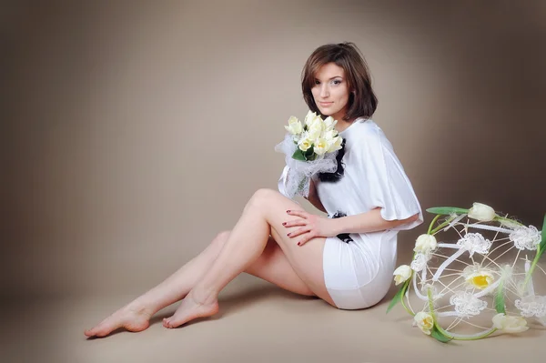 Mooi meisje in de studio met een bos van bloemen — Stockfoto