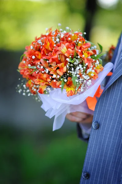 Noivo detém um buquê de casamento — Fotografia de Stock